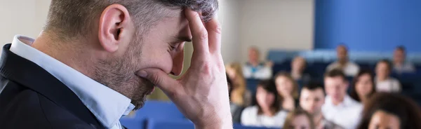 Trött professor under föreläsning med studenter — Stockfoto