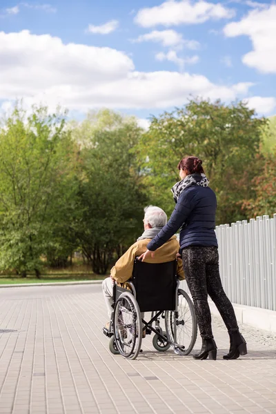 Homme en fauteuil roulant avec infirmière — Photo