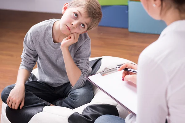 Pojke uttråkad av samtal med psykolog — Stockfoto