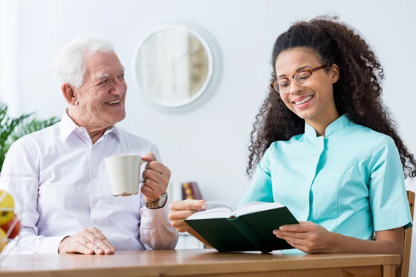 Verpleegkundige helpen om een boek te lezen — Stockfoto