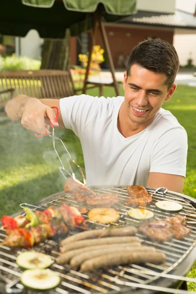 En mann som forbereder grill for venner – stockfoto
