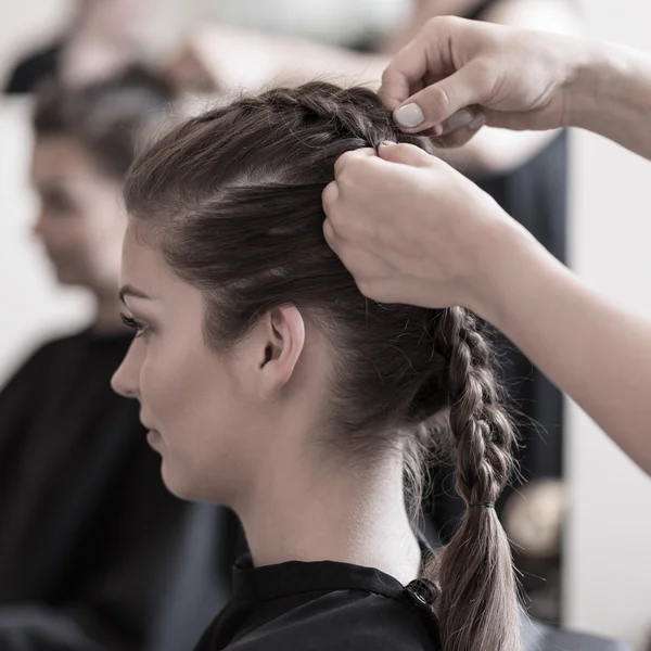 Braiding young woman's hair — Stock Photo, Image