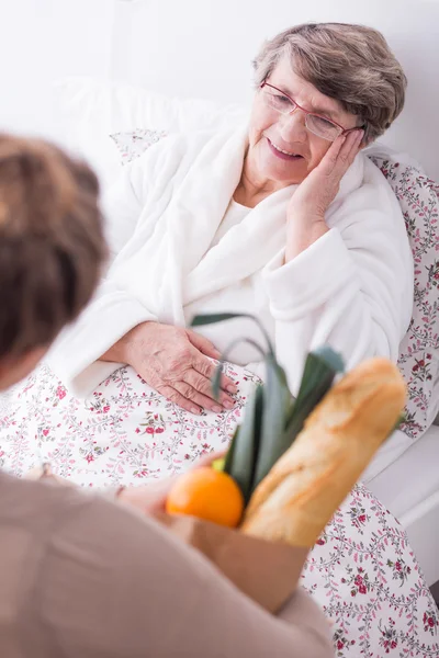 Mulher visitando doente sênior — Fotografia de Stock