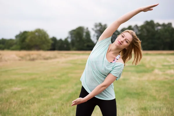 Doing side stretch outside — Stock Photo, Image