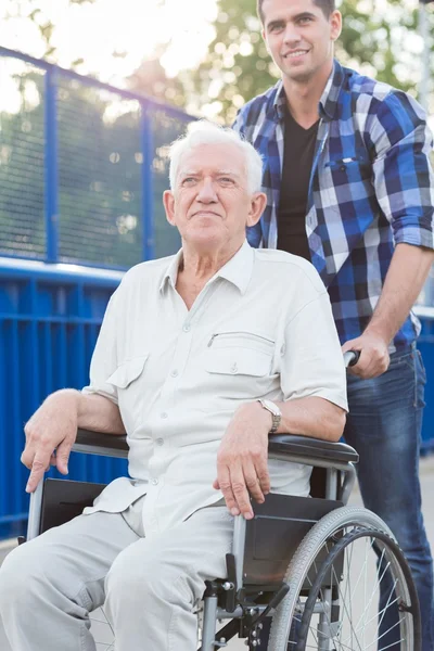 Uomo sorridente sulla sedia a rotelle — Foto Stock