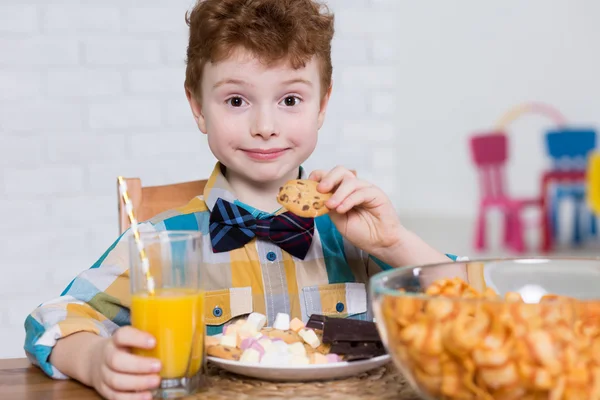 Little glutton and plate full of sweets — Stock Photo, Image