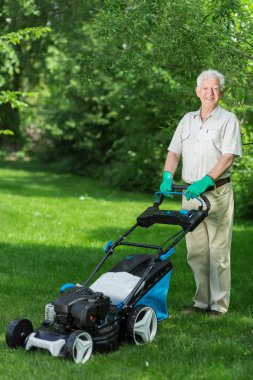 Çim biçme makinesi kullanan adam