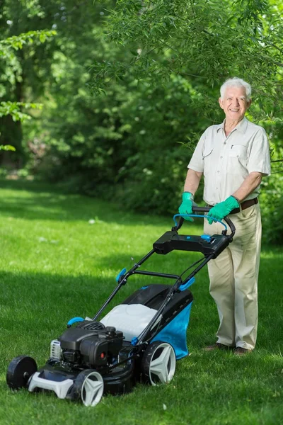 Çim biçme makinesi kullanan adam