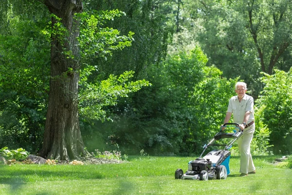 Gepensioneerde man het gras maaien — Stockfoto