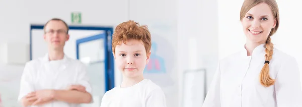 Kind, arts en verpleegkundige bij pediatrische medische kliniek — Stockfoto