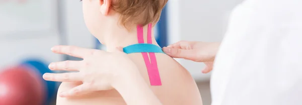 Fyzioterapeut pásky na dítě — Stock fotografie