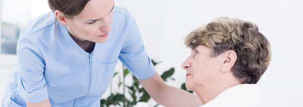 Nuttig verpleegkundige en zieke patiënt — Stockfoto