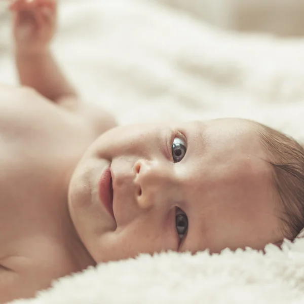 Lächelndes Kind auf Decke liegend — Stockfoto