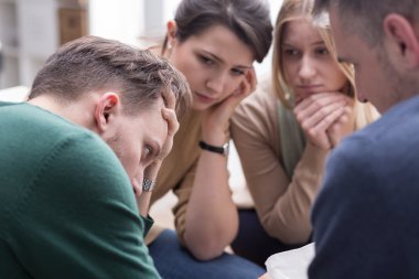 Rahatlatıcı genç adam grup terapi seansı sırasında insanlar