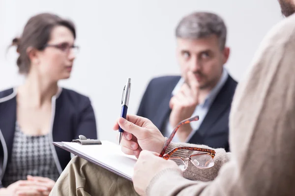 Terapeuta tomando notas durante la sesión de terapia matrimonial — Foto de Stock