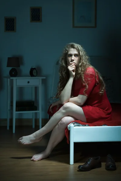 Pensive woman sitting on bed — Stock Photo, Image