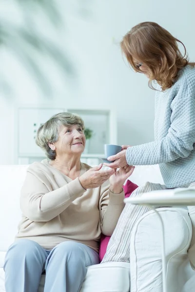 Servir du thé à une dame plus âgée — Photo