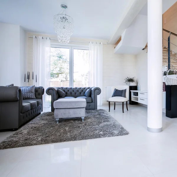 Prostorný, světlý obývací pokoj s kamenným schodištěm — Stock fotografie