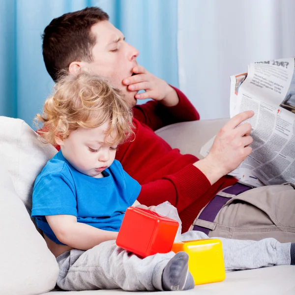 Bored dad reads the newspaper — Stock Photo, Image