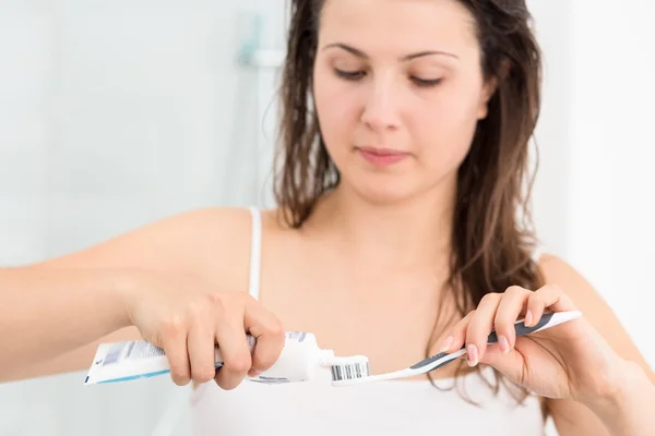 Женщина сжимает зубную пасту — стоковое фото