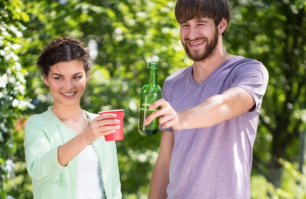 Muž a žena, opékání nápoje v zahradní slavnost — Stock fotografie