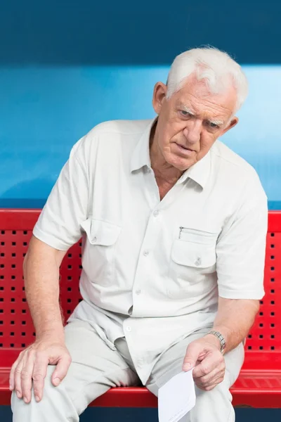 Emeryturze człowiek siedzi na ławce — Zdjęcie stockowe