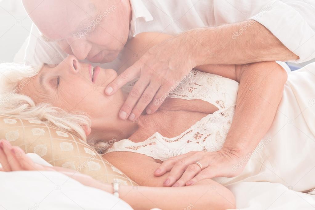 взрослая пара в постели. мужчина и женщина в постели. близость пожилых. женщины в возрасте занимаются любовью. страстные пожилые женщины.