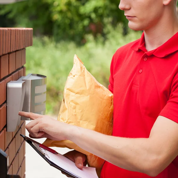 Delivery guy calling on entryphone — Stock Photo, Image