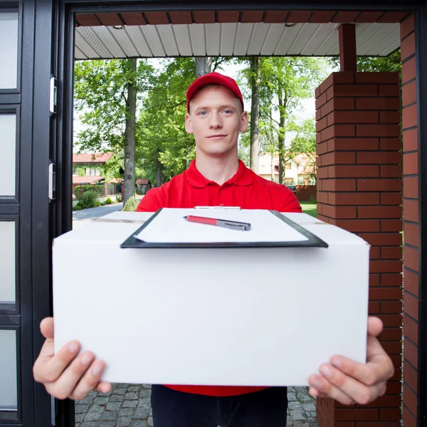 Delivery guy handing in parcel — Stock Photo, Image