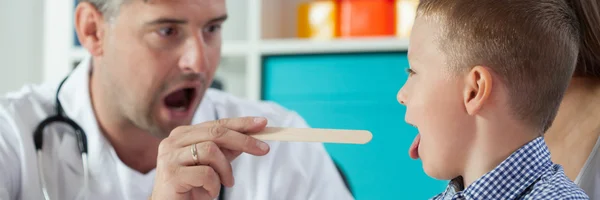 Pediatra examina la garganta del niño — Foto de Stock