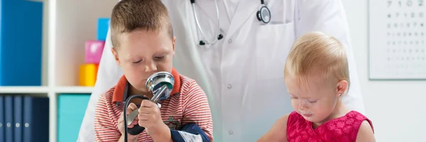 Cute siblings sitting at pediatrician — Stock Photo, Image