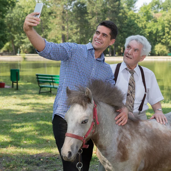 Man taking selfie with grandfather — Stock Photo, Image