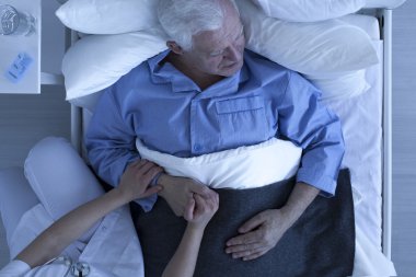 Doktor veya hemşire üst düzey hastanın elini tutarak
