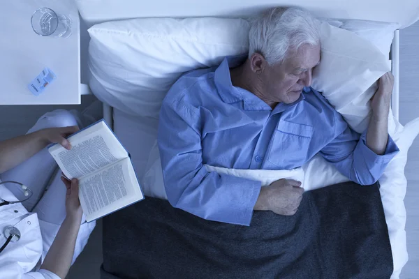 Verpleegkundige lezen voor senior patiënt — Stockfoto