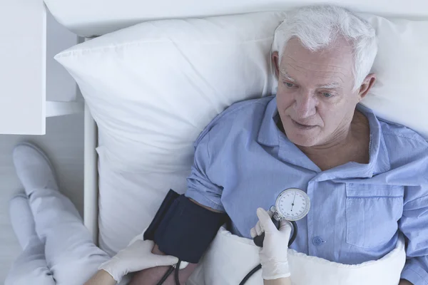 Enfermera midiendo la presión arterial del paciente — Foto de Stock