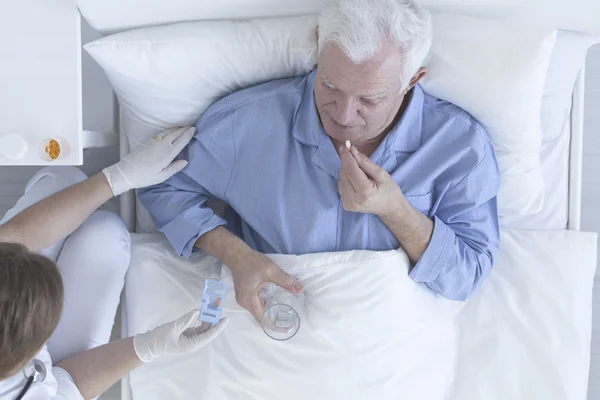 Patienten tar piller med glas vatten — Stockfoto