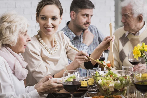 Kvinna som serverar middag till sin familj — Stockfoto