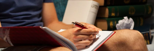 Estudante escrevendo em seu caderno . — Fotografia de Stock