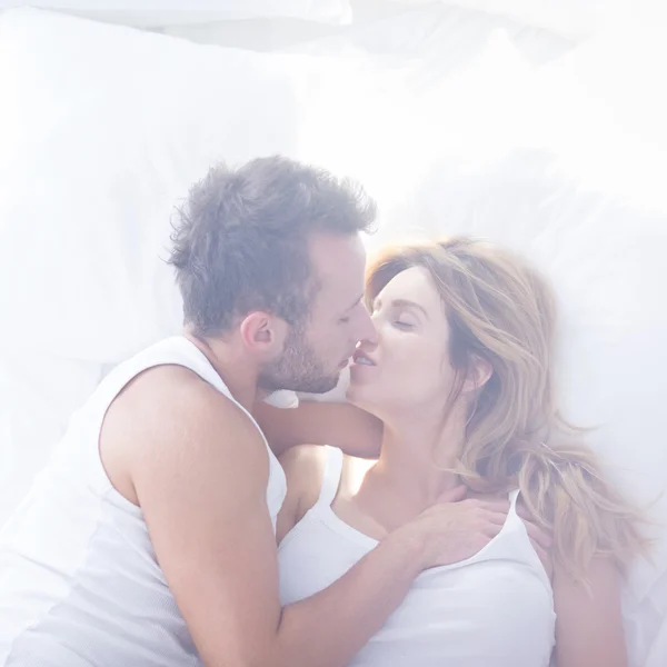 Romantic lovers kissing in bed — Stock Photo, Image