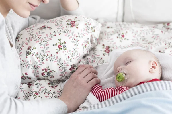 Schlafendes Baby und vorsichtige Mutter — Stockfoto