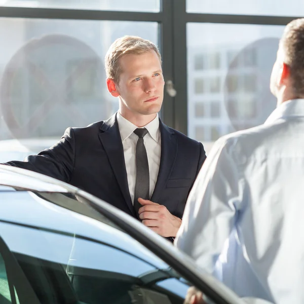 Автомобильный агент разговаривает с клиентами — стоковое фото