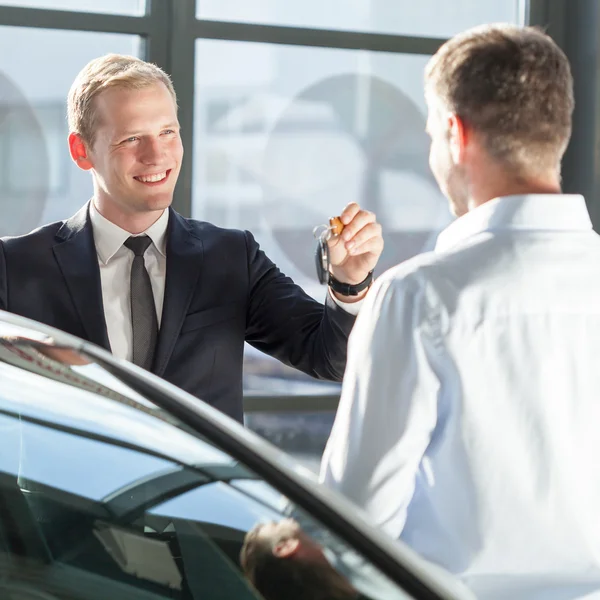 Verkäufer gibt Autoschlüssel ab — Stockfoto