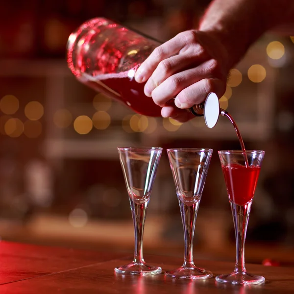 Barman pouring red shots — Stock Photo, Image