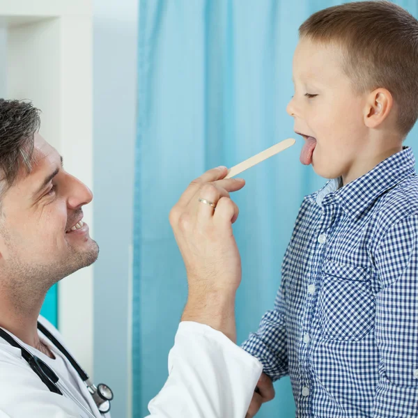 Barnläkare undersökande pojkens hals — Stockfoto