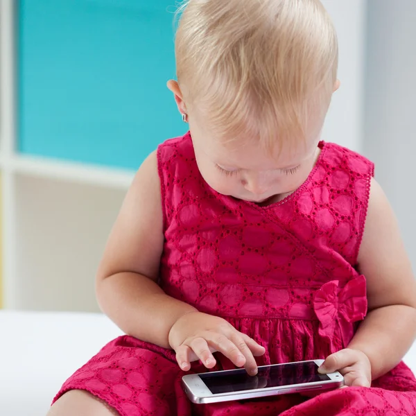 Malá dívka si hraje s počítačem tablet — Stock fotografie