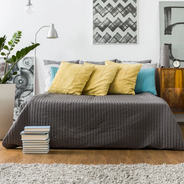 Bed with decorative yellow pillows — Stock Photo, Image