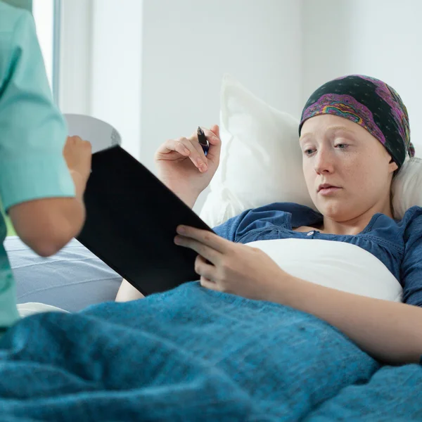 Cancer kvinna underteckna dokument — Stockfoto