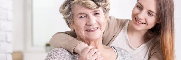 Vrouw omhelst mooie grootmoeder — Stockfoto