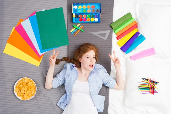 Menina jovem e arte em uma cama — Fotografia de Stock