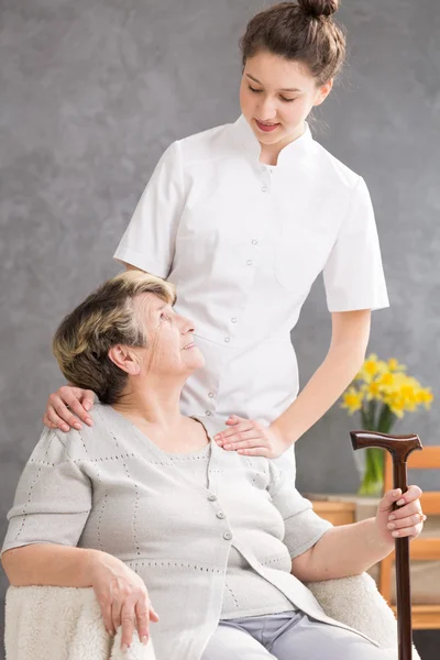 Senior senhora e prestativa cuidador — Fotografia de Stock